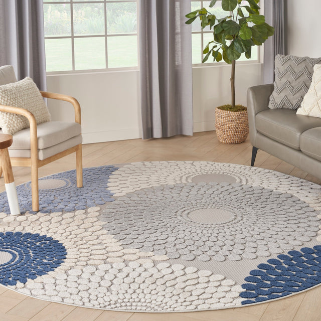 Round area rug with blue and grey geometric medallion pattern and light cream background