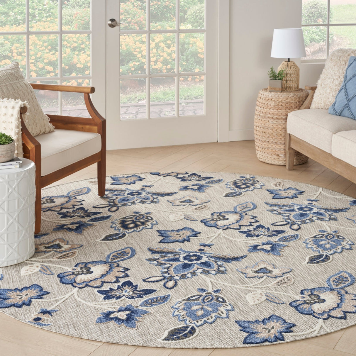 Blue-gray round rug with ornate floral and medallion pattern, soft woven texture