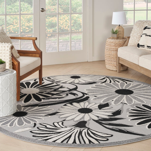 Round black-and-white floral rug with scalloped daisy motifs