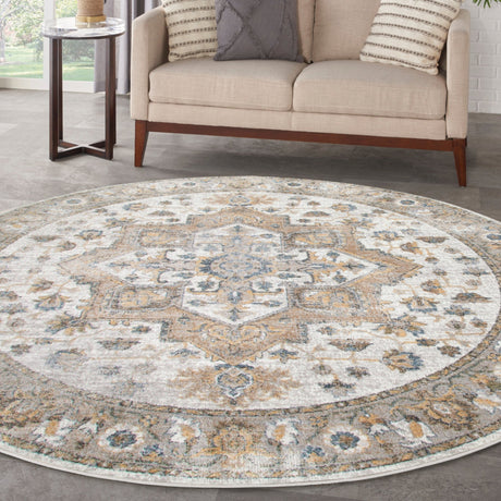Round silver grey rug with large ornate medallion and blue/tan motifs