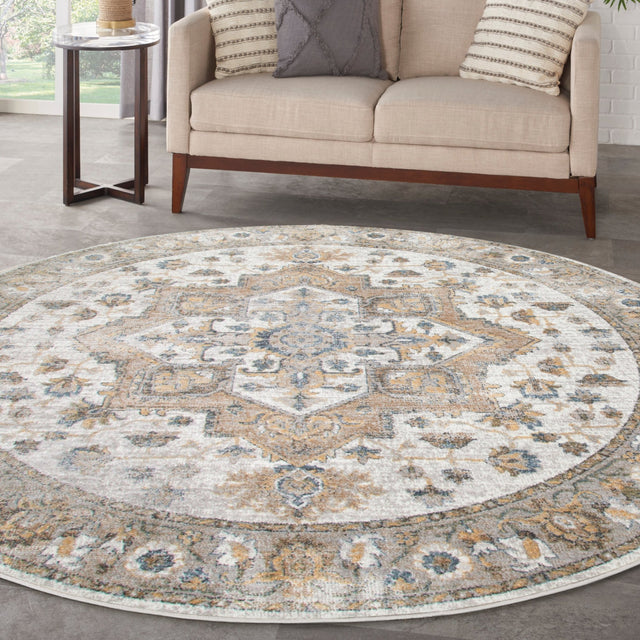 Round silver grey rug with large ornate medallion and blue/tan motifs