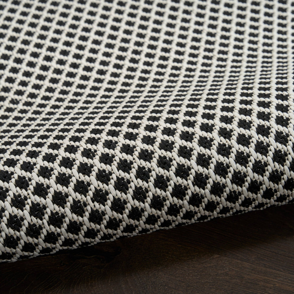 Black and white lattice rug with looped texture along the edge