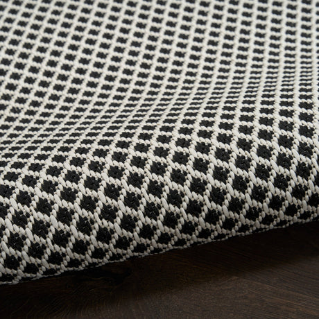 Black and white lattice rug with looped texture along the edge