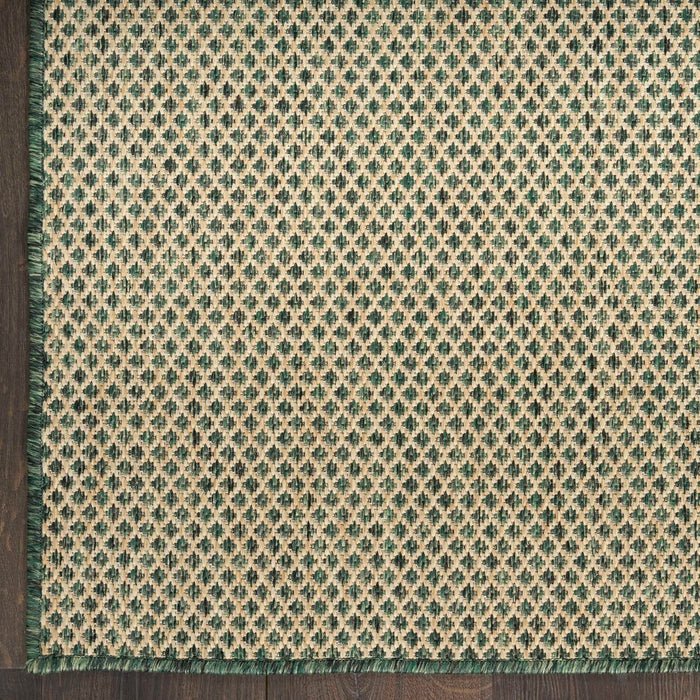 Green area rug close-up showing diamond lattice pattern with textured, flat weave