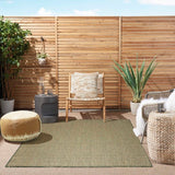 Green outdoor-style rug with repeating diamond lattice pattern and flat woven texture