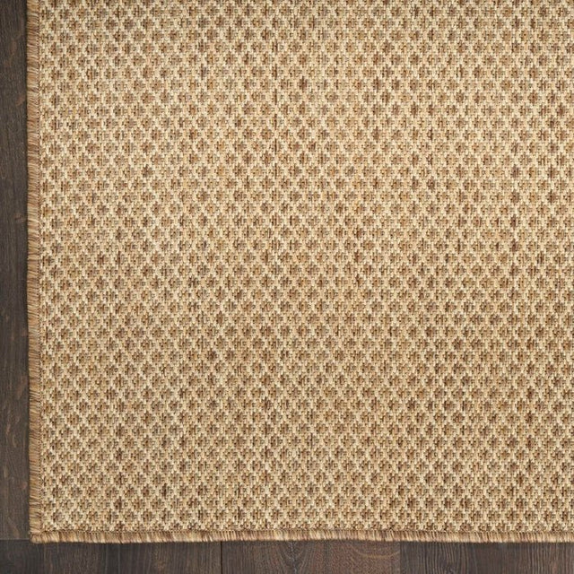 Tan jute rug with dense woven diamond pattern close-up