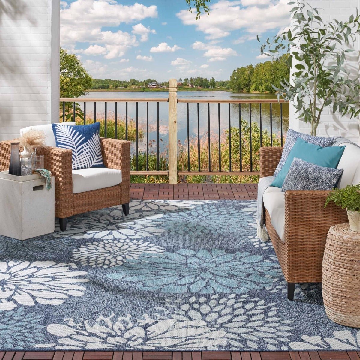 Navy and light blue floral area rug on balcony floor with large white botanical print