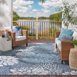 Navy and light blue floral area rug on balcony floor with large white botanical print