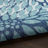 Navy and light blue area rug close-up showing raised textured floral pattern