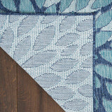 Navy and light blue area rug corner with white grid floral detailing and border
