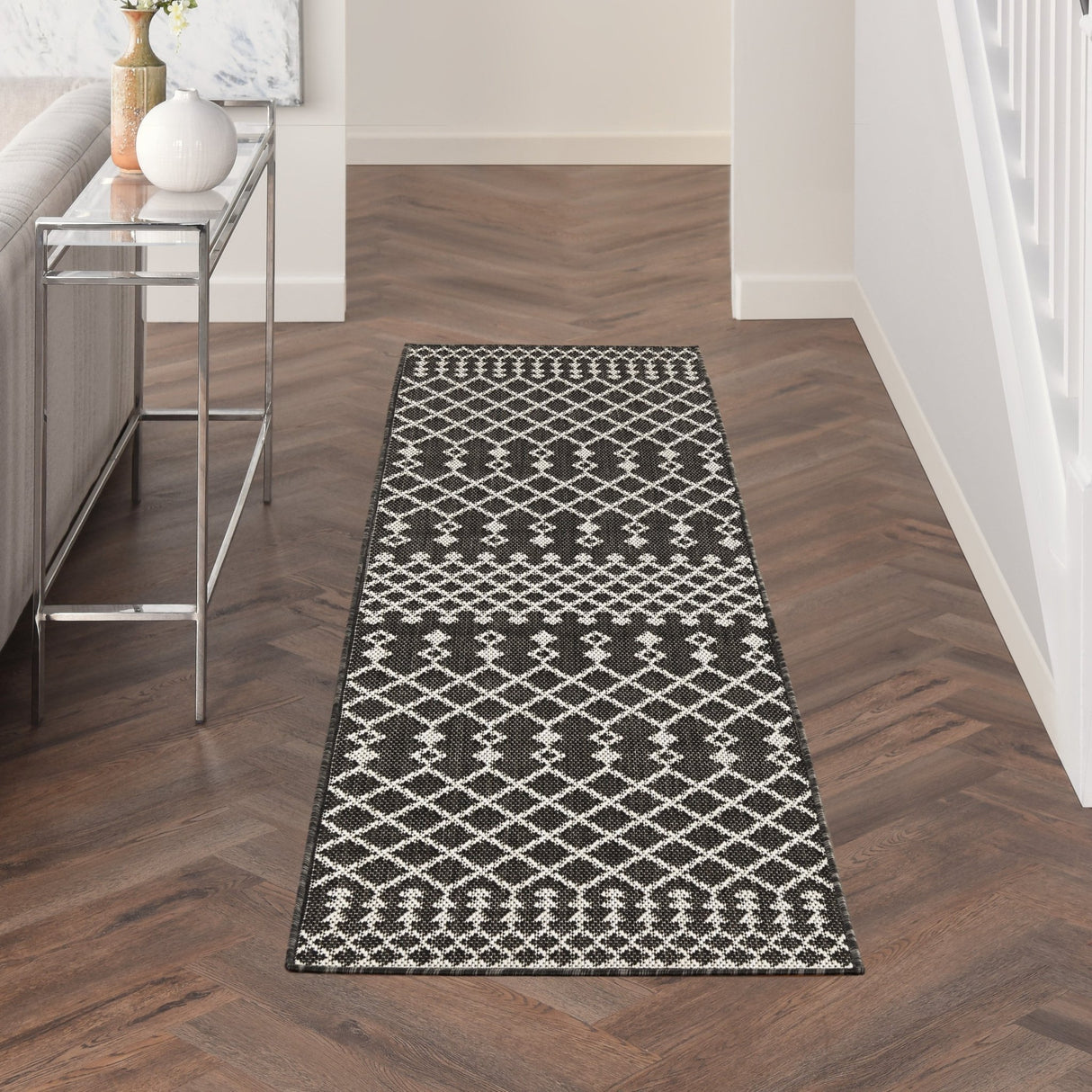 Black rectangular rug with white diamond lattice pattern and ornate border