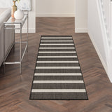 Rectangular black and ivory striped rug with stitched border and low pile