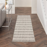 Rectangular grey-and-ivory striped rug laid in hallway on dark wood floor