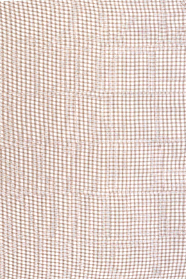 Outdoor rug pad with small square mesh grid in light tone and warm accents