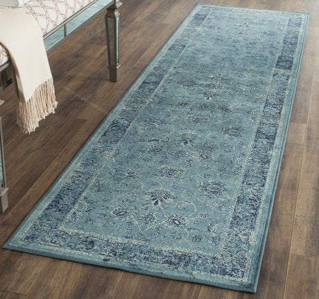 Vintage-style runner rug in light blue with ornate distressed design and border