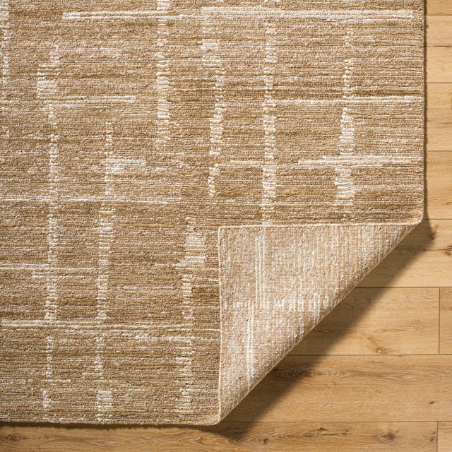 Handmade rug corner with tan and cream abstract motif and flat textured surface