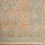 Handmade rug with distressed geometric pattern, beige center, teal accents, rust border