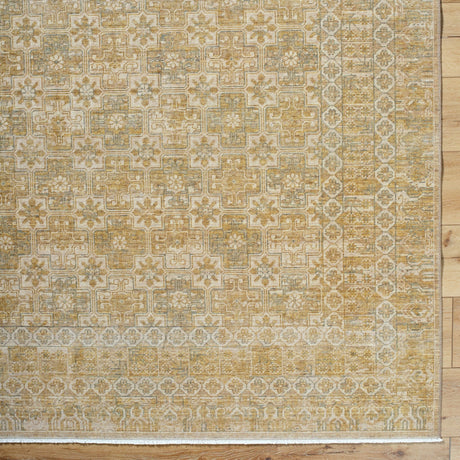 Handmade area rug with ornate geometric pattern in gold, beige, and ivory.