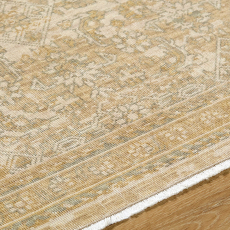 Handmade rug close-up: beige textured weave with gold geometric motifs and bound edge