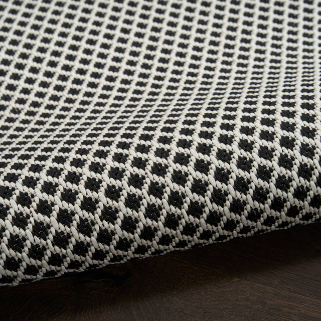 Black and white lattice rug with looped texture along the edge